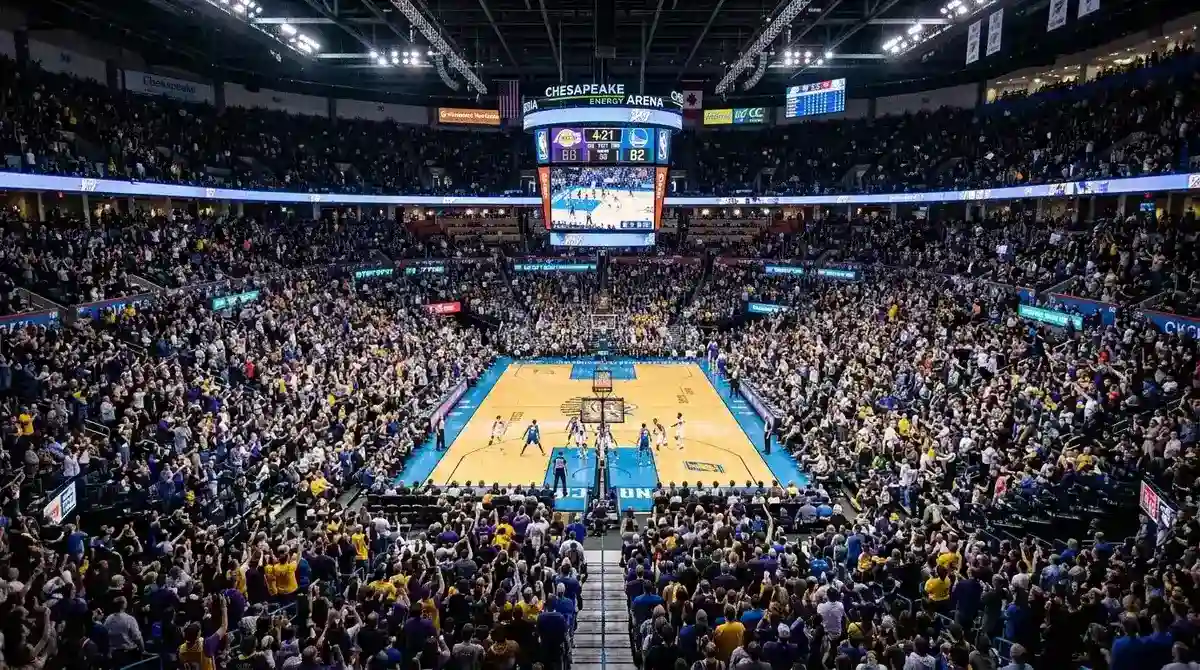 Packed NBA arena during a live basketball game with bright court lighting and scoreboard visible